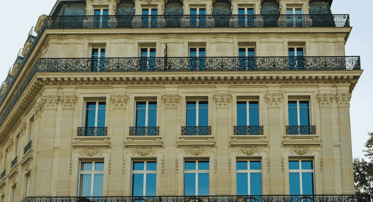 Façade haussmannienne typique avec balcons en fer forgé et fenêtres ornementées