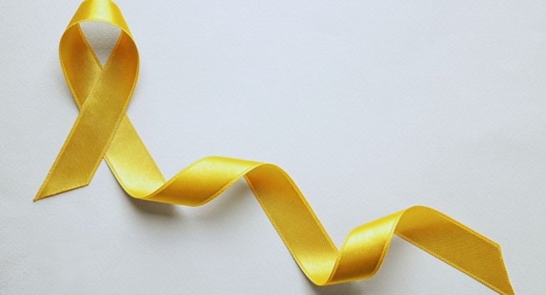 Ruban jaune noué symbole de sensibilisation sur fond blanc
