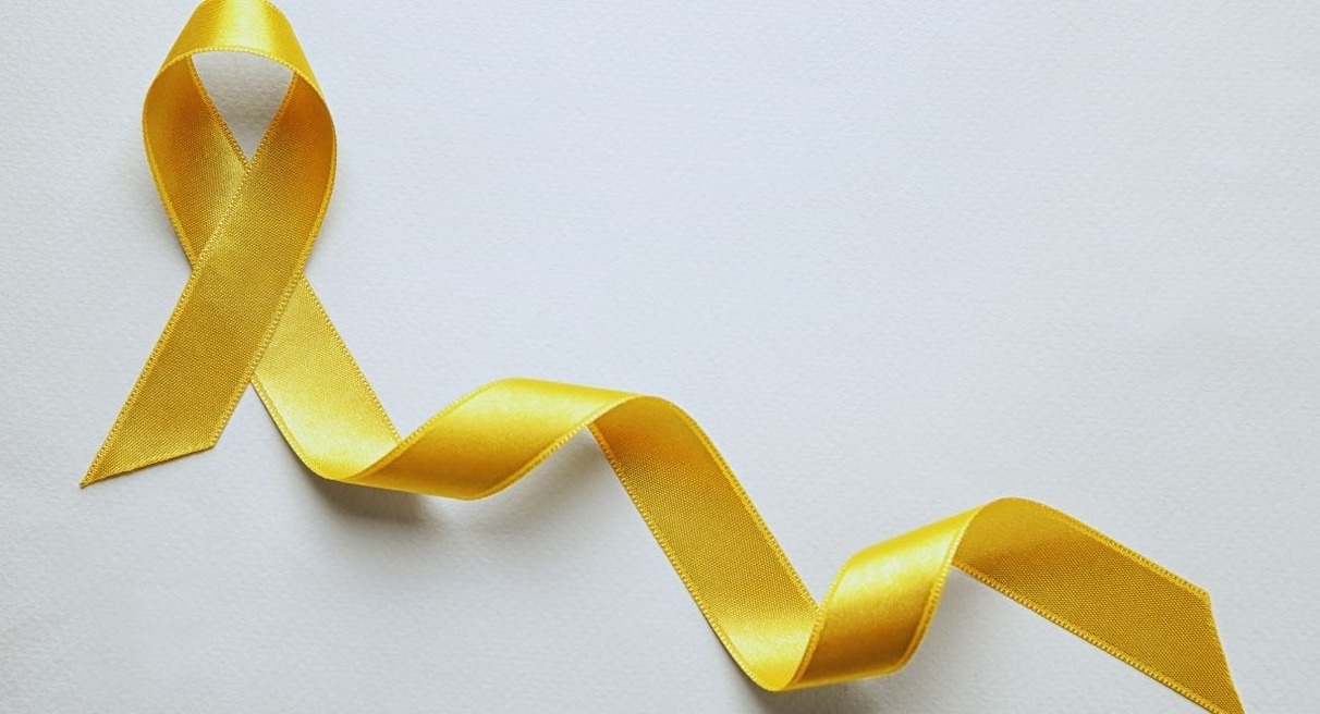 Ruban jaune noué symbole de sensibilisation sur fond blanc