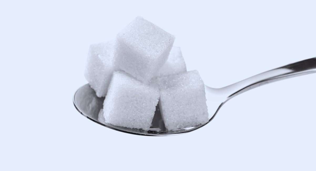 Cuillère portant plusieurs morceaux de sucre blanc en cube